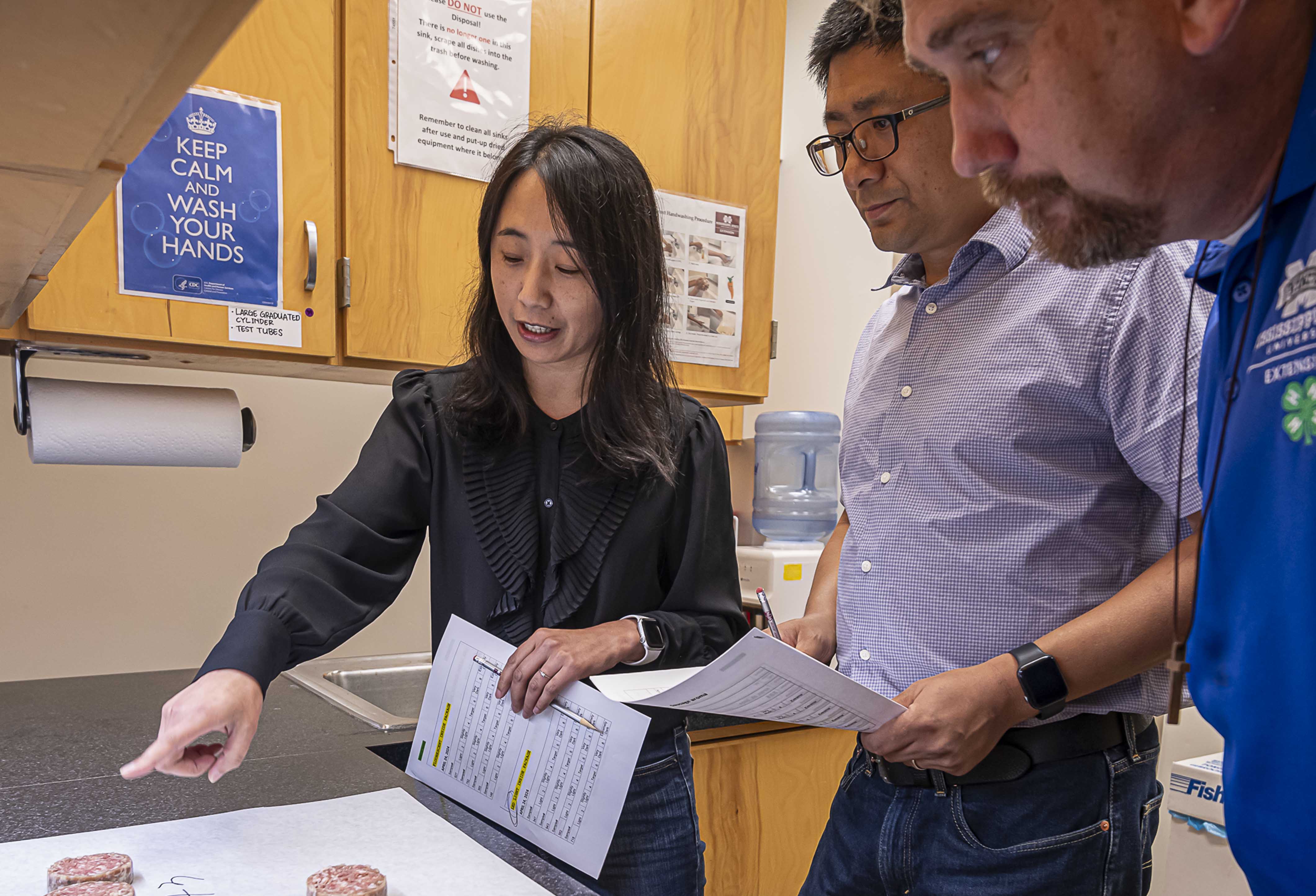 Drs. Xue Zhang, Li Zhang, and Wes Schilling discuss treatments to extend the shelf life of pork sausage. (Photo by David Ammon) 